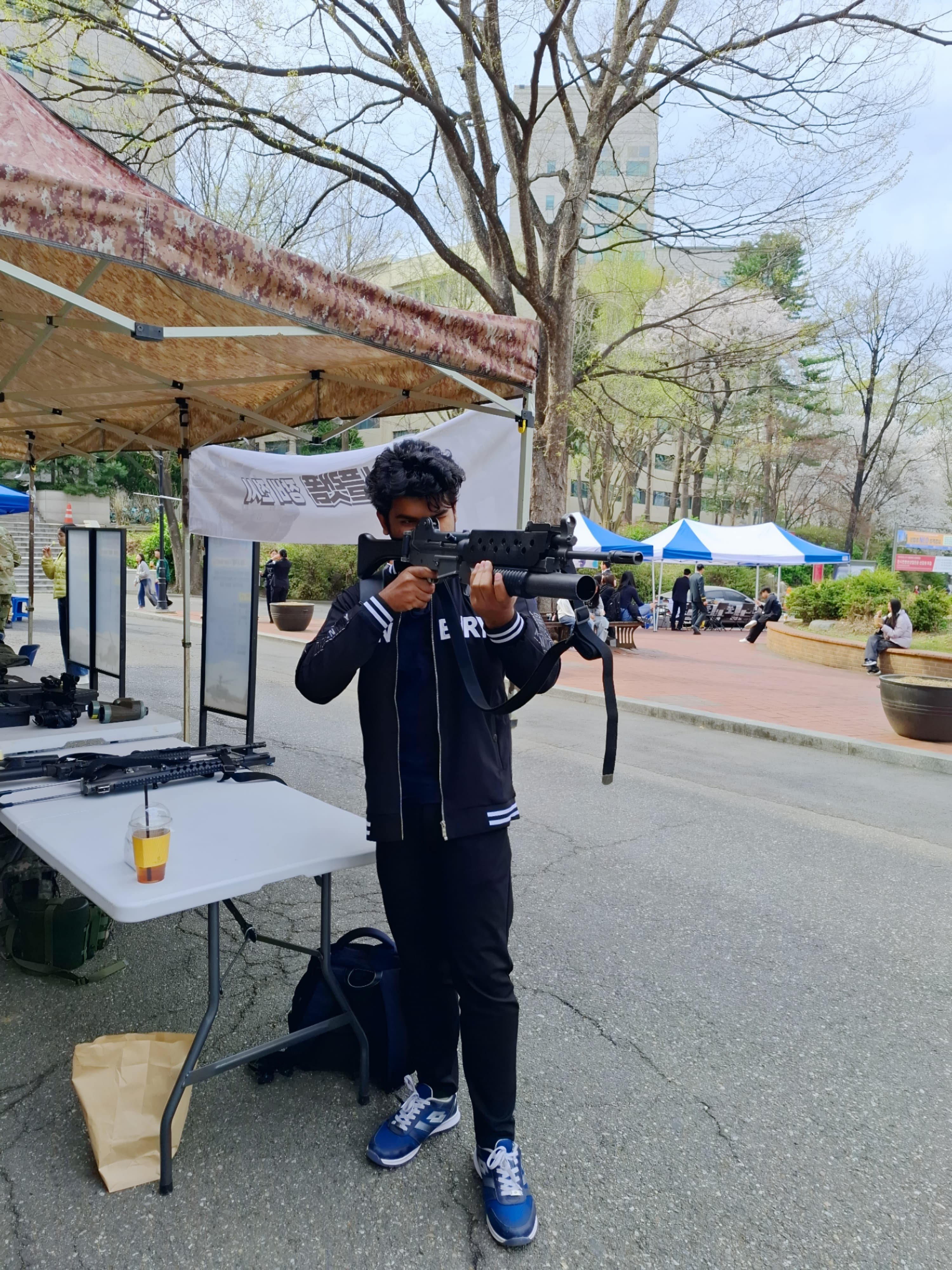 Shawkat Hossain Maruf trying a military rifle at the ROTC recruitment event on campus at Sejong University.