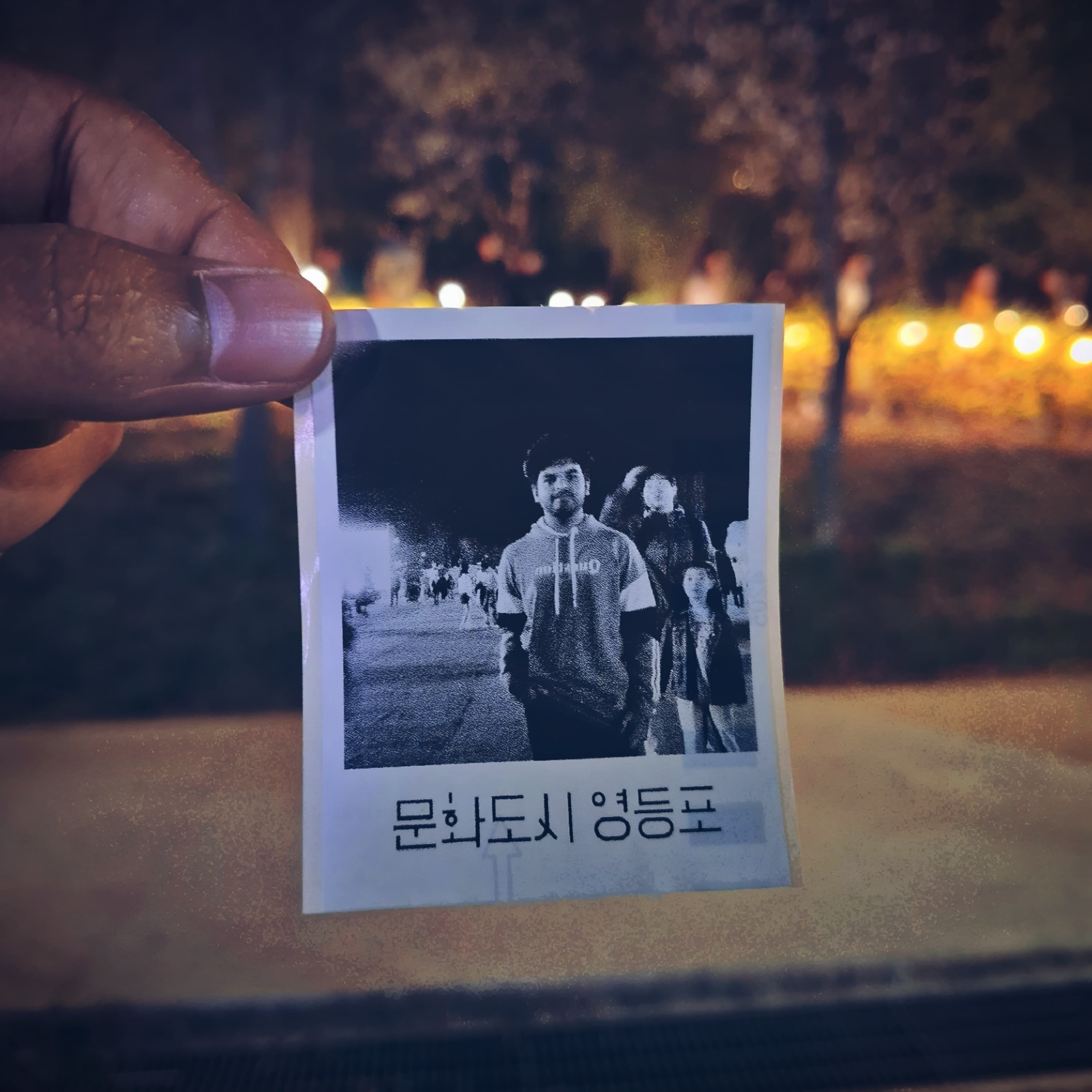 Shawkat Hossain Maruf captured in a vintage Polaroid photo taken at a stall during the Yeouido Cherry Blossom Festival in Seoul.